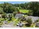Aerial view of a charming house with a well-manicured lawn, mature trees, and a pond nearby at 6576 Pebble Beach Crescent, Myrtle Beach, SC 29588