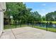 Concrete patio with black metal railing overlooking backyard with mature trees and pond at 6576 Pebble Beach Crescent, Myrtle Beach, SC 29588