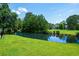 Scenic backyard view with a serene pond and lush green surroundings at 6576 Pebble Beach Crescent, Myrtle Beach, SC 29588