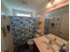 Bathroom featuring a shower with a colorful curtain, shelves and vanity for toiletries, and a window at 671 American Beech St., Loris, SC 29569
