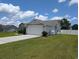 Side view of the home displaying the driveway, two car garage, and fenced in yard at 671 American Beech St., Loris, SC 29569