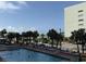 Outdoor pool with palm trees, lounge chairs, and the ocean in the background, perfect for relaxation at 6900 N Ocean Blvd. # 201, Myrtle Beach, SC 29572