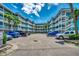 Condominium complex featuring ample parking and tropical landscaping on a sunny day at 720 N Waccamaw Dr. # 205, Garden City Beach, SC 29576