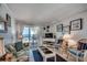 Bright living room with a glass-top coffee table, comfortable seating, and stunning ocean views from the balcony at 720 N Waccamaw Dr. # 205, Garden City Beach, SC 29576