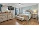 Spacious bedroom with an upholstered bed frame, an ottoman, and natural light coming in from the windows at 775 Plantation Dr. # 53, Little River, SC 29566