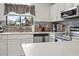 Well-lit kitchen showcasing stainless steel appliances, white cabinetry, and tiled backsplash at 775 Plantation Dr. # 53, Little River, SC 29566