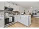 Open kitchen with stainless steel appliances, white cabinetry, and view into the living room at 775 Plantation Dr. # 53, Little River, SC 29566