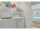 Bright laundry room with a washer and dryer, wire shelving, and natural light streaming in through the window at 775 Plantation Dr. # 53, Little River, SC 29566