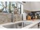 Close-up of kitchen sink with a modern faucet, decorative backsplash, and natural light at 775 Plantation Dr. # 53, Little River, SC 29566