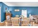 Warm dining area with a wooden table set for six, a large window, and a blue accent wall at 788 Dusty Pine Way, Myrtle Beach, SC 29588