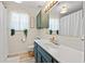 Charming bathroom featuring a blue vanity, plants, and wood-look flooring at 890 Knoll Dr., Little River, SC 29566