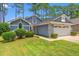 Charming home featuring a two-car garage, manicured lawn and low foundation shrubbery at 890 Knoll Dr., Little River, SC 29566