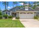 Charming home featuring a two-car garage, manicured lawn and low foundation shrubbery at 890 Knoll Dr., Little River, SC 29566