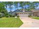 Charming home featuring a two-car garage, manicured lawn and low foundation shrubbery at 890 Knoll Dr., Little River, SC 29566