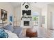 Open-concept living room with fireplace, mantel, and large TV, seamlessly connected to the dining area at 890 Knoll Dr., Little River, SC 29566