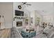 Open-concept living room with fireplace, mantel, and large TV, seamlessly connected to the dining area at 890 Knoll Dr., Little River, SC 29566