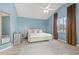 Calming main bedroom with blue walls, white ceiling fan, and natural light at 890 Knoll Dr., Little River, SC 29566
