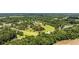 An aerial view highlights a home in a verdant, community setting with lush greenery, homes, and a school nearby at 903 N Park St. Ext., Mullins, SC 29574