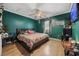 A bedroom with green walls, wood-look flooring, ceiling fan, and a black platform bed at 903 N Park St. Ext., Mullins, SC 29574