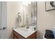 Bright bathroom featuring a wood vanity, white sink, and large mirror at 908 Ashbourn Ct., Murrells Inlet, SC 29576