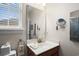 Bathroom featuring a window for natural light, a cabinet, vanity, and large mirror at 908 Ashbourn Ct., Murrells Inlet, SC 29576