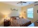 Bright bedroom featuring a ceiling fan, queen bed with floral bedding and side tables with lamps at 908 Ashbourn Ct., Murrells Inlet, SC 29576