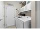 Bright laundry room with white washer and dryer, white cabinets, and door to the outside at 908 Ashbourn Ct., Murrells Inlet, SC 29576