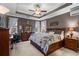 Comfortable main bedroom featuring tray ceilings, soft carpet, and a large wooden bed frame with storage at 908 Ashbourn Ct., Murrells Inlet, SC 29576