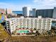 High-angle view showcases condo with ocean backdrop, pool, and ample parking at 9400 Shore Dr. # 409, Myrtle Beach, SC 29572
