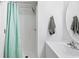 Clean bathroom with a white shower featuring a light green shower curtain, and a white sink at 9400 Shore Dr. # 409, Myrtle Beach, SC 29572