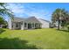 Well-maintained backyard with a patio, lush lawn, and mature trees for privacy at 946 Wyndfall Dr., Sunset Beach, NC 28468