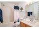 Bright bathroom featuring a shower with curtain, wood vanity, and decorative accents at 946 Wyndfall Dr., Sunset Beach, NC 28468