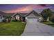 Charming one-story home with a well-kept lawn and a driveway, illuminated at sunset at 946 Wyndfall Dr., Sunset Beach, NC 28468