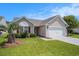 Charming single-story home with well-manicured lawn and two-car garage on a bright day at 946 Wyndfall Dr., Sunset Beach, NC 28468