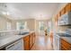 Kitchen with wood cabinets, double sink, open to living and dining areas at 946 Wyndfall Dr., Sunset Beach, NC 28468