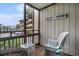 Cozy screened balcony with seating and parking lot views, perfect for relaxing and enjoying the coastal breeze at 9501 Shore Dr. # 135, Myrtle Beach, SC 29572