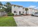 Inviting townhouse featuring a neatly landscaped front yard, a patio set, and convenient parking space at 951 Plantation Dr. # F1, Little River, SC 29566