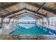 Indoor pool area featuring a high wood ceiling, deck chairs and tables, and large windows at 9550 Shore Dr. # 225, Myrtle Beach, SC 29572