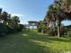 Lush green yard with a beachfront cottage in the distance, surrounded by palm trees at 5732 N Ocean Blvd., Myrtle Beach, SC 29577