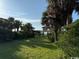 Green lawn with a cottage and a wooden walkway amid palm trees and tropical greenery at 5732 N Ocean Blvd., Myrtle Beach, SC 29577