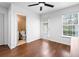 Bright, open bedroom with hardwood floors, ceiling fan, a bathroom view and a sliding glass door with window at 108 Barnacle Ln. # 4, Little River, SC 29566