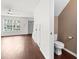 Hallway view showcasing hardwood floors, a toilet room and views of the living room through a doorway at 108 Barnacle Ln. # 4, Little River, SC 29566