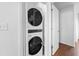 Convenient laundry area features stacked washer and dryer in a closet with white door in the hallway at 108 Barnacle Ln. # 4, Little River, SC 29566
