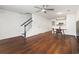 Bright, open-concept living area with hardwood floors and a ceiling fan, adjacent to a kitchen and staircase at 108 Barnacle Ln. # 4, Little River, SC 29566