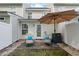 Serene patio with lounge chairs, vibrant blue pillows, shade umbrella, and view of the rear exterior of home at 108 Barnacle Ln. # 4, Little River, SC 29566