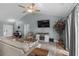 Cozy living room features vaulted ceiling, ceiling fan, TV, fireplace, and sliding glass door at 1100 Rosetta Dr., Conway, SC 29526