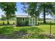 Green outbuilding with covered porch, sitting on a large lot with a bright sunny lawn at 1100 Rosetta Dr., Conway, SC 29526