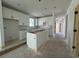 Spacious kitchen with white cabinets and a center island awaiting countertops in an unfinished home at 1221 Lady Bird Way, North Myrtle Beach, SC 29582