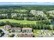 Aerial view of a community with homes nestled next to a golf course and surrounded by lush greenery at 125 South Shore Dr. # 204, Longs, SC 29568