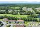 Aerial view of a community with homes nestled next to a golf course and surrounded by lush greenery at 125 South Shore Dr. # 204, Longs, SC 29568